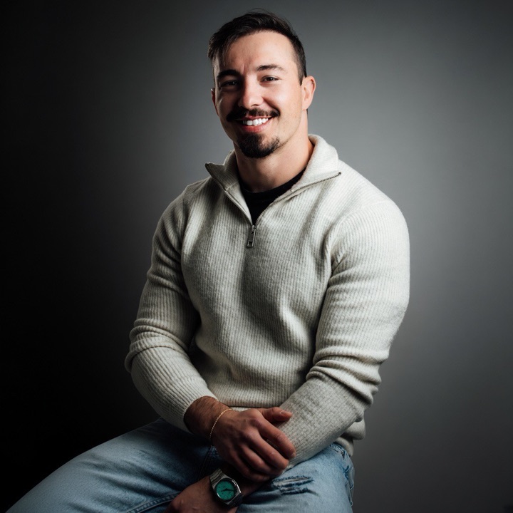 Jalison Cecato, autor do livro, sentado e sorrindo.